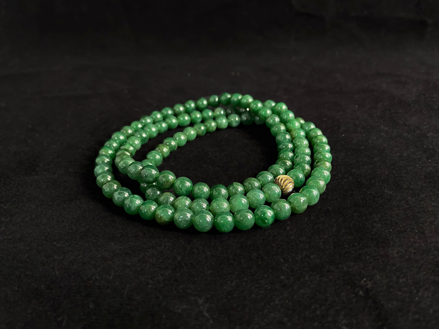 This elegant jade necklace combines spinach green beads with a silver gold plated focal bead, creating a perfect balance of natural beauty and metallic elegance.
