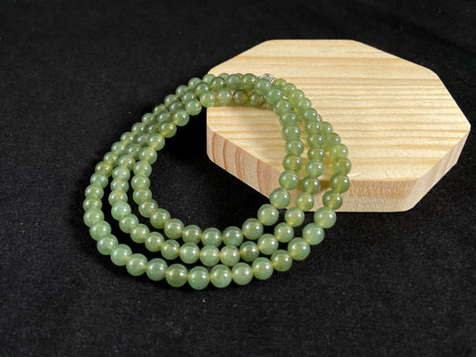 A jade bead strand composed of translucent dark green beads.