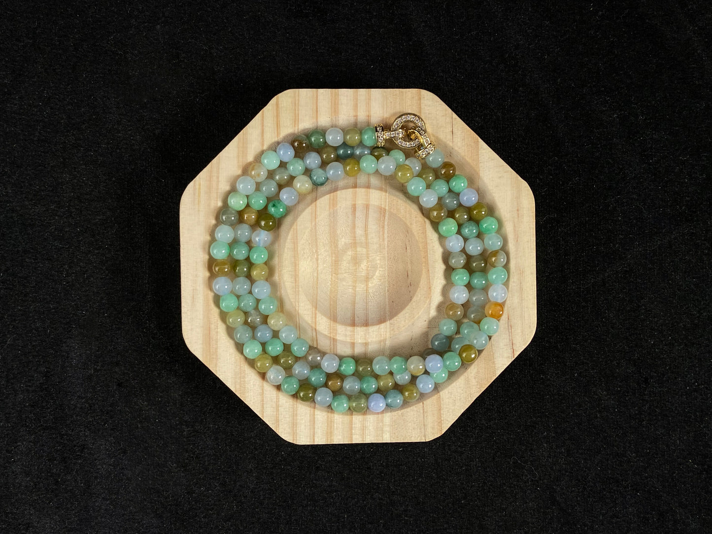 A jade bead strand featuring light green, creamy white and green beads