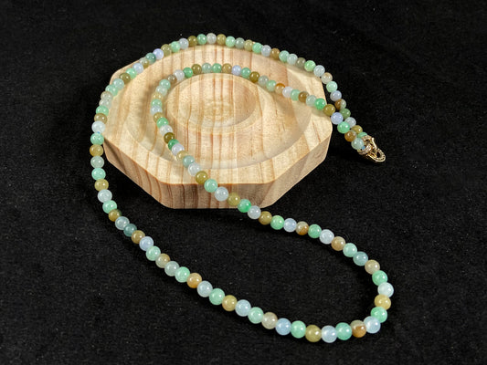 A jade bead strand featuring light green, creamy white and green beads