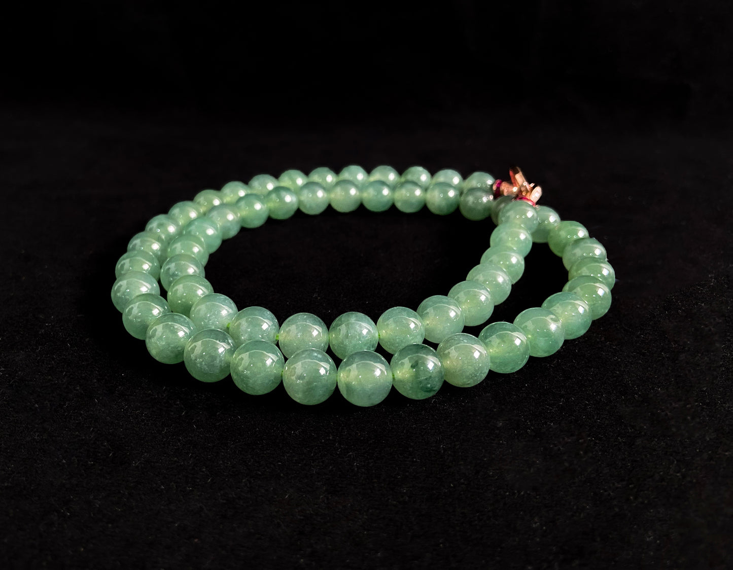 A jade necklace featuring translucent green beads with crystalline clarity.