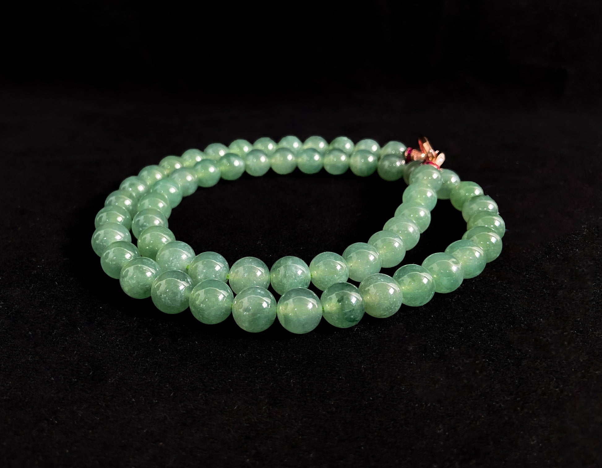 A jade necklace featuring translucent green beads with crystalline clarity.