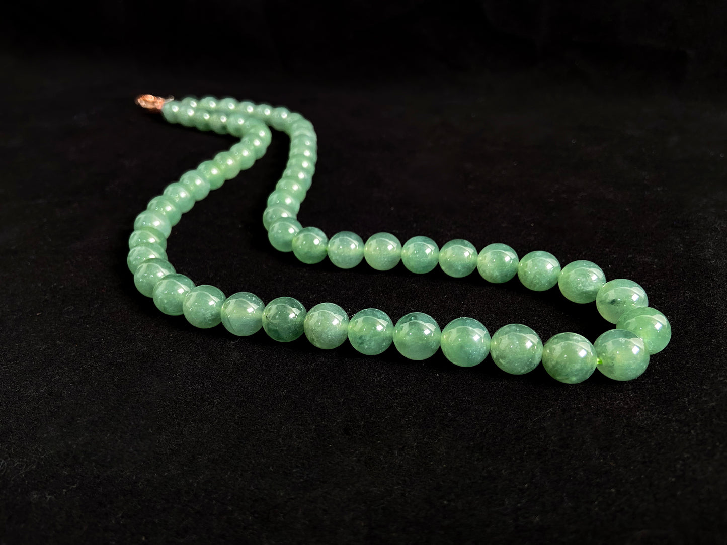 A jade necklace featuring translucent green beads with crystalline clarity.