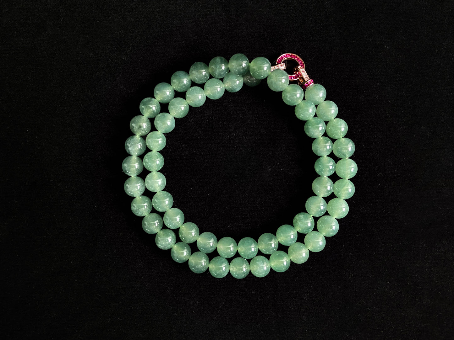 A jade necklace featuring translucent green beads with crystalline clarity.
