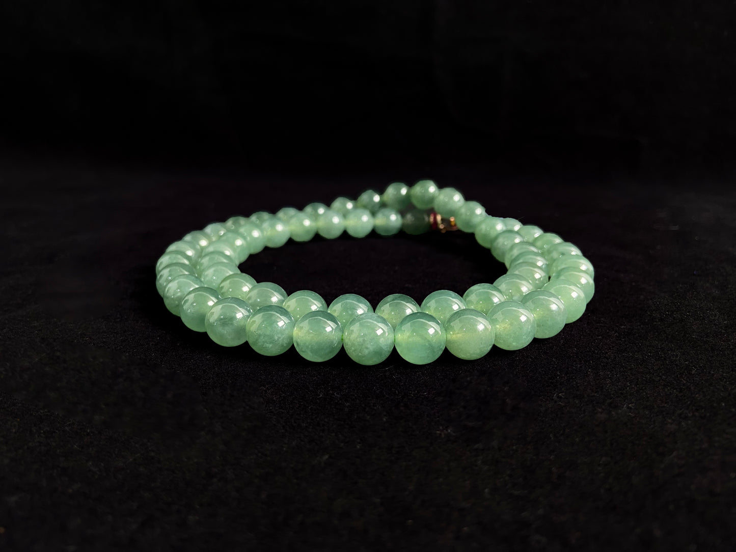 A jade necklace featuring translucent green beads with crystalline clarity.