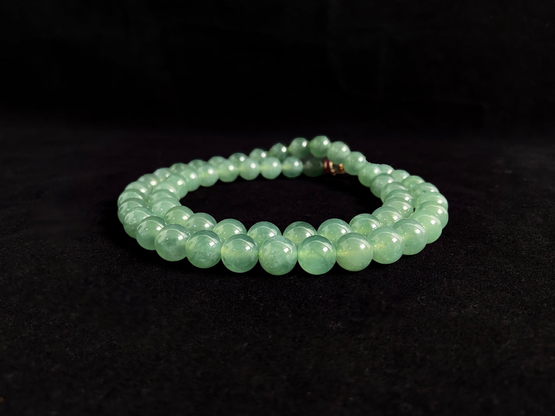 A jade necklace featuring translucent green beads with crystalline clarity.