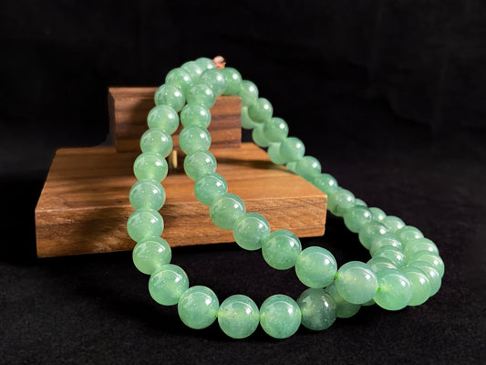 A jade necklace featuring translucent green beads with crystalline clarity.