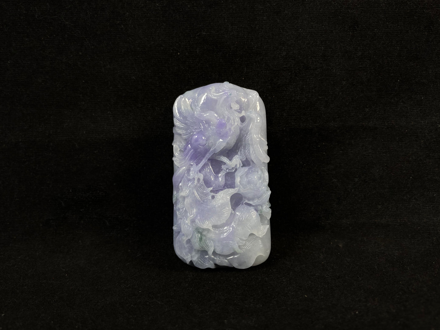A purple jade stone carved with a phoenix design.