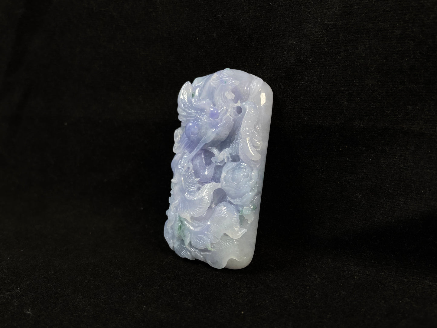 A purple jade stone carved with a phoenix design.