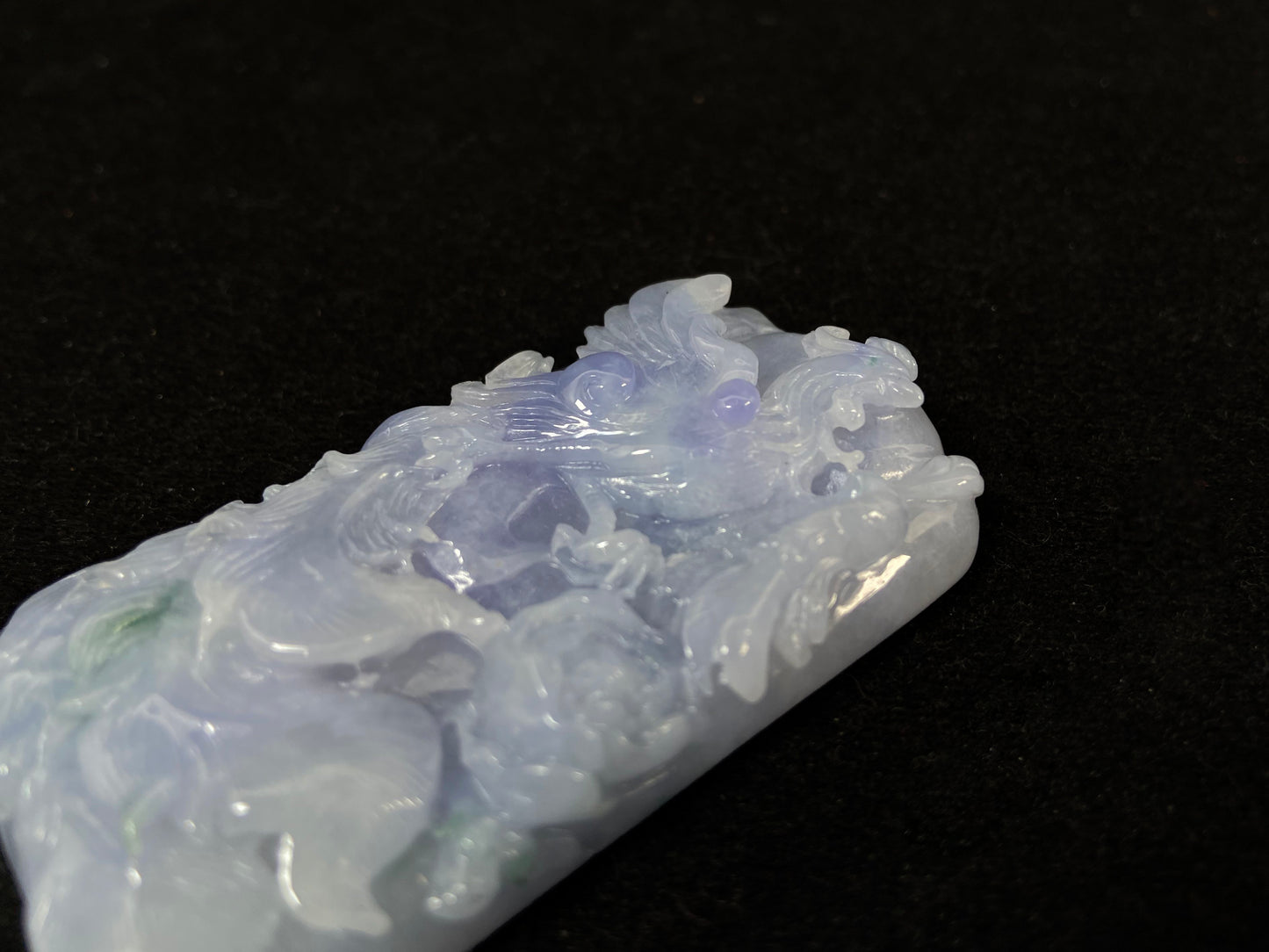 A purple jade stone carved with a phoenix design.