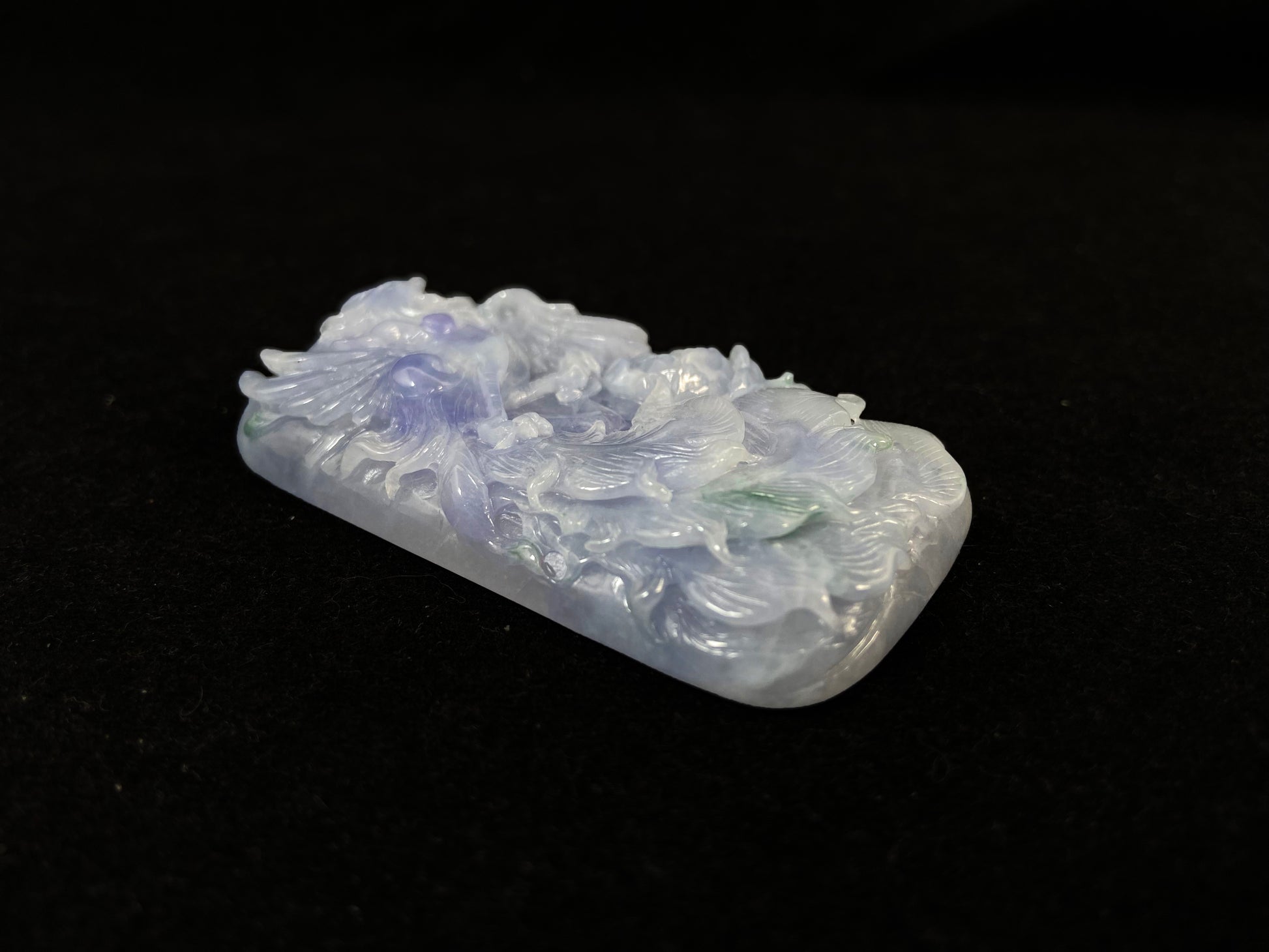 A purple jade stone carved with a phoenix design.
