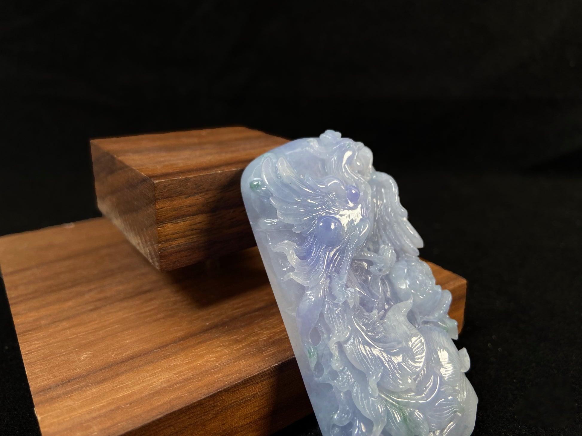 A purple jade stone carved with a phoenix design.