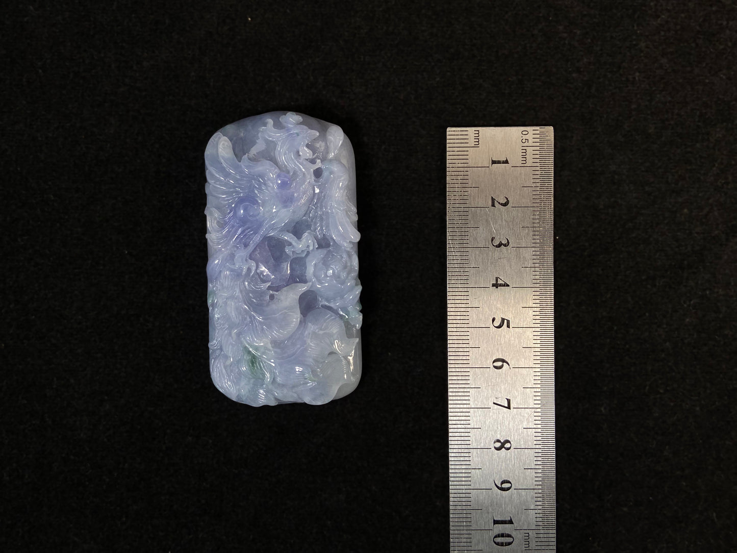 A purple jade stone carved with a phoenix design.