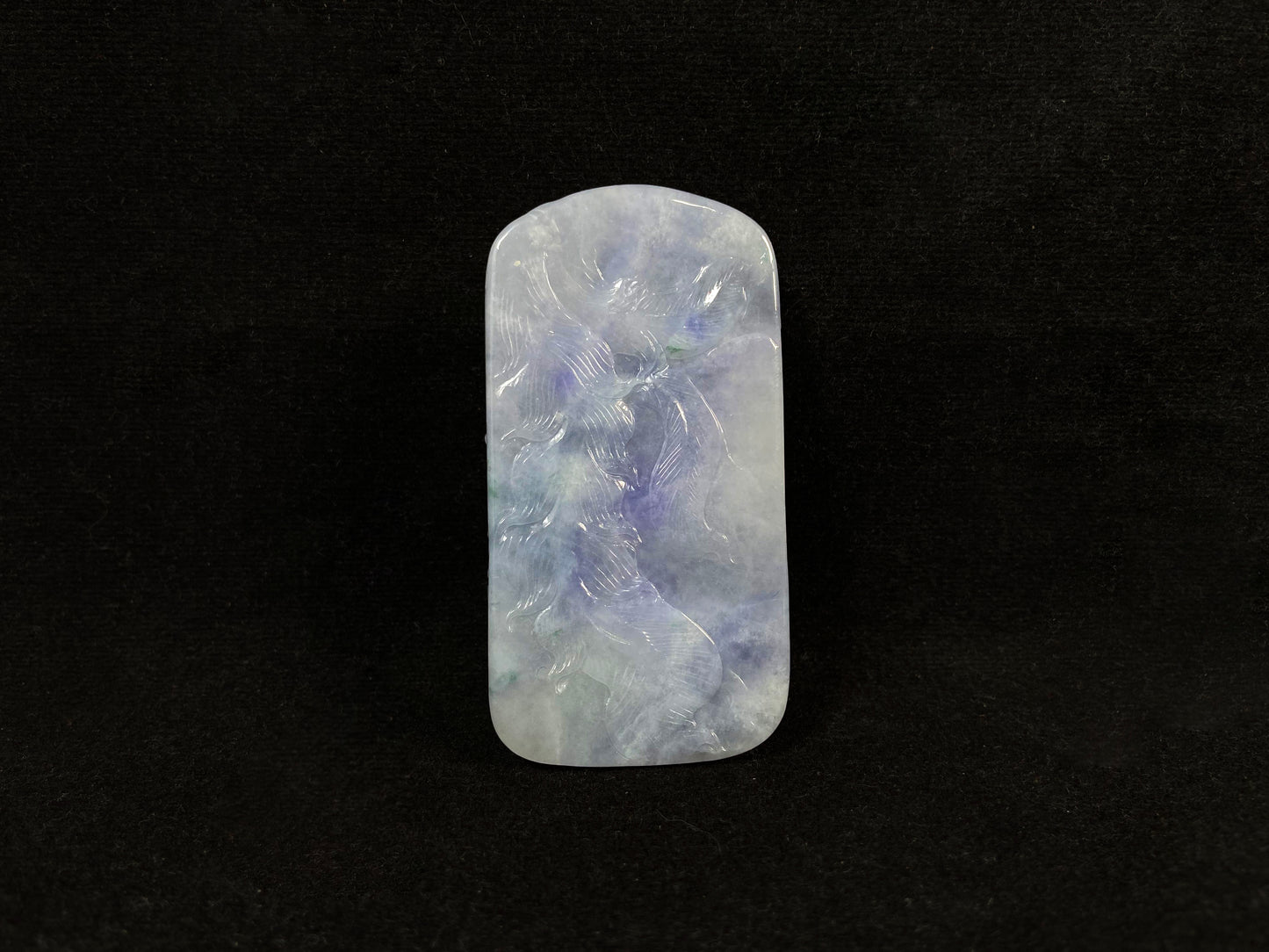 A purple jade stone carved with a phoenix design.
