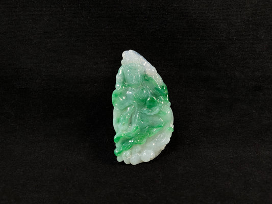 A Guanyin jade carving with a creamy white base and large green areas.