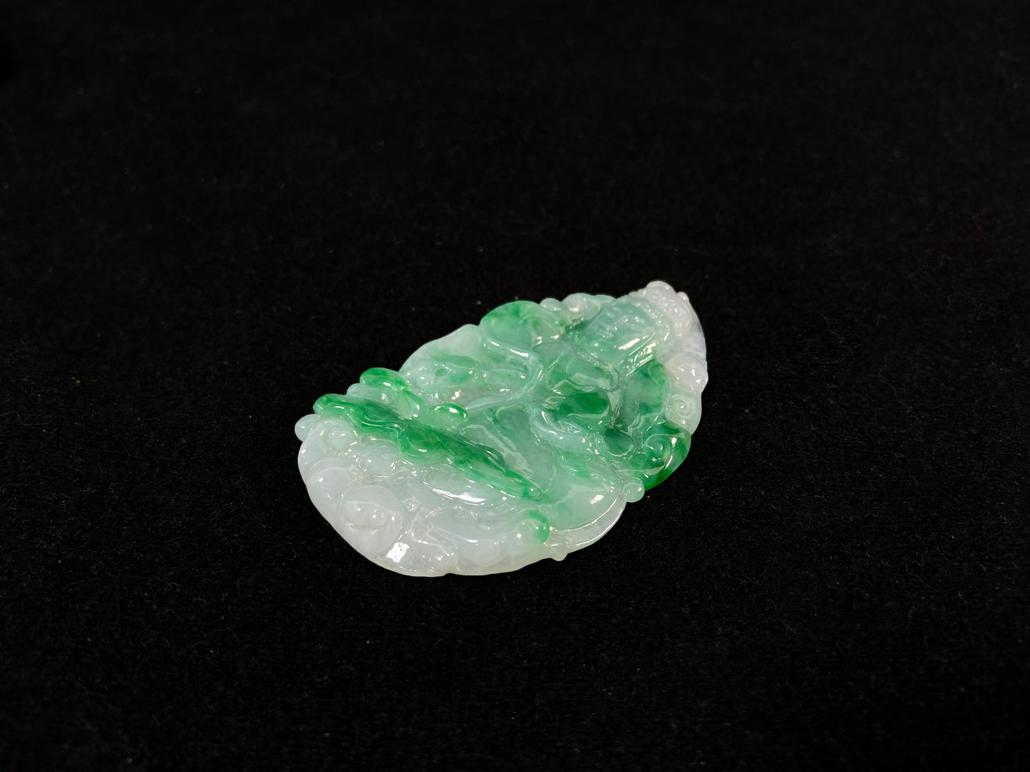 A Guanyin jade carving with a creamy white base and large green areas.