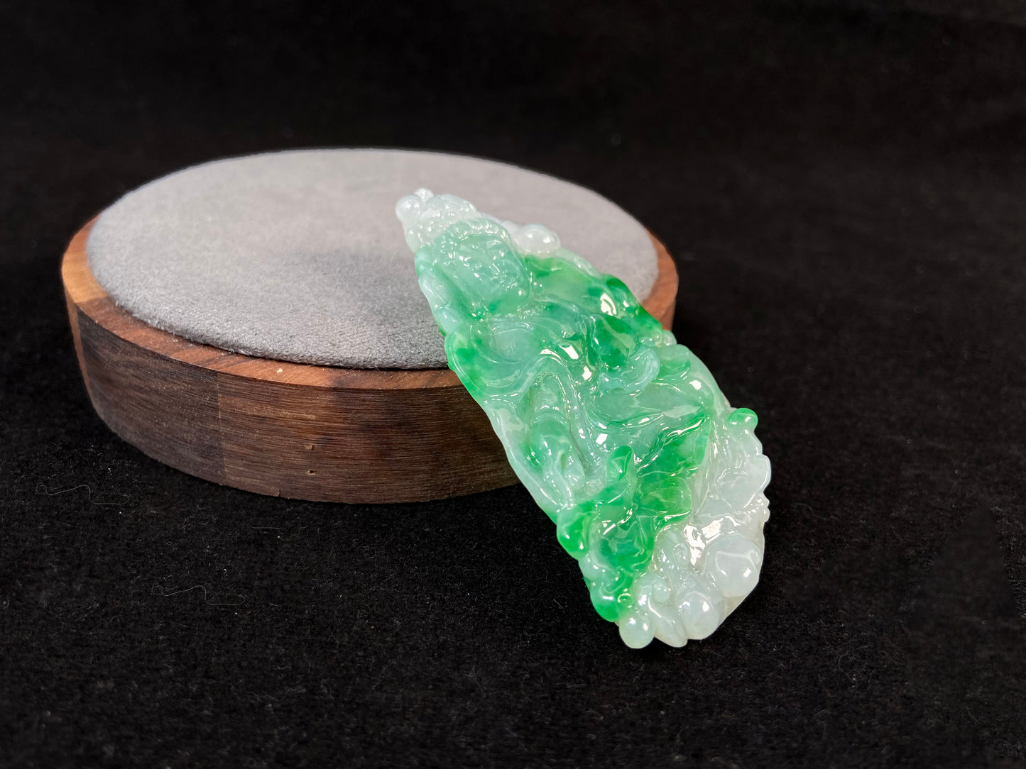 A Guanyin jade carving with a creamy white base and large green areas.