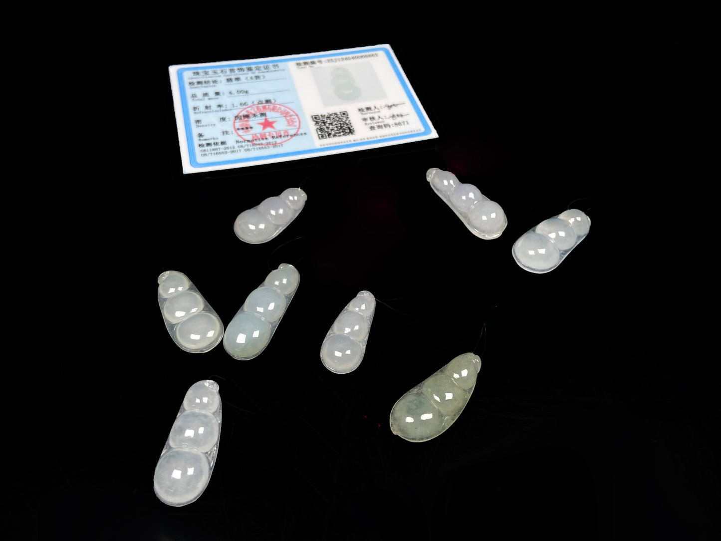 A group of pale green and icy white lucky pea pod loose jadeite.