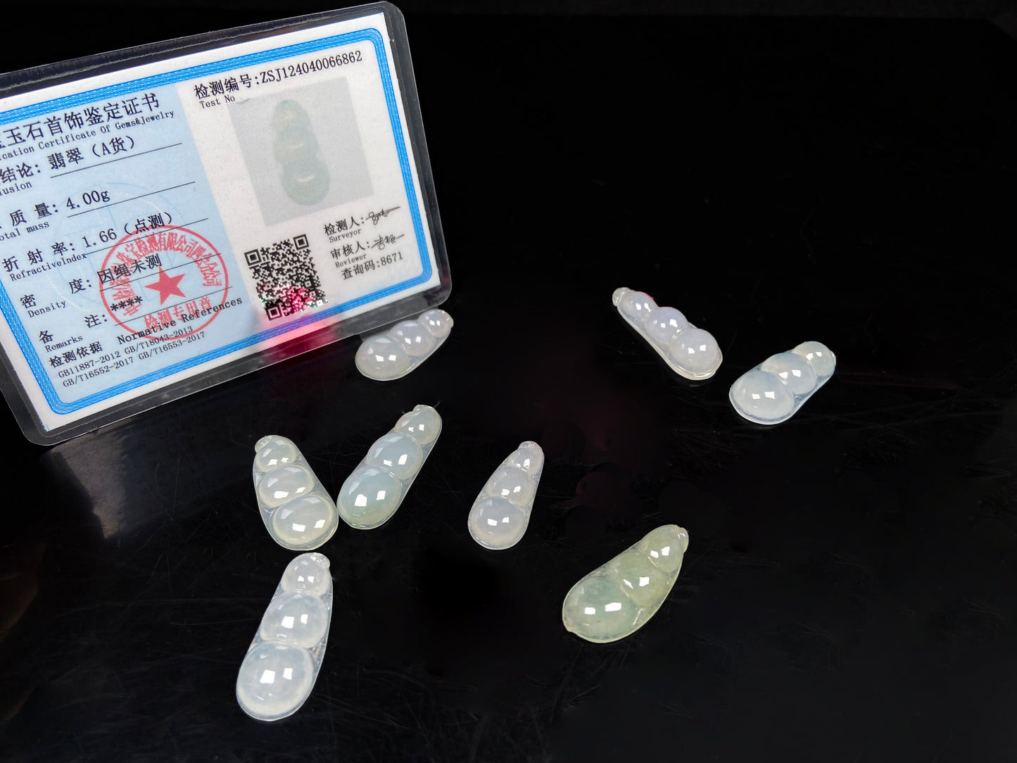 A group of pale green and icy white lucky pea pod loose jadeite.