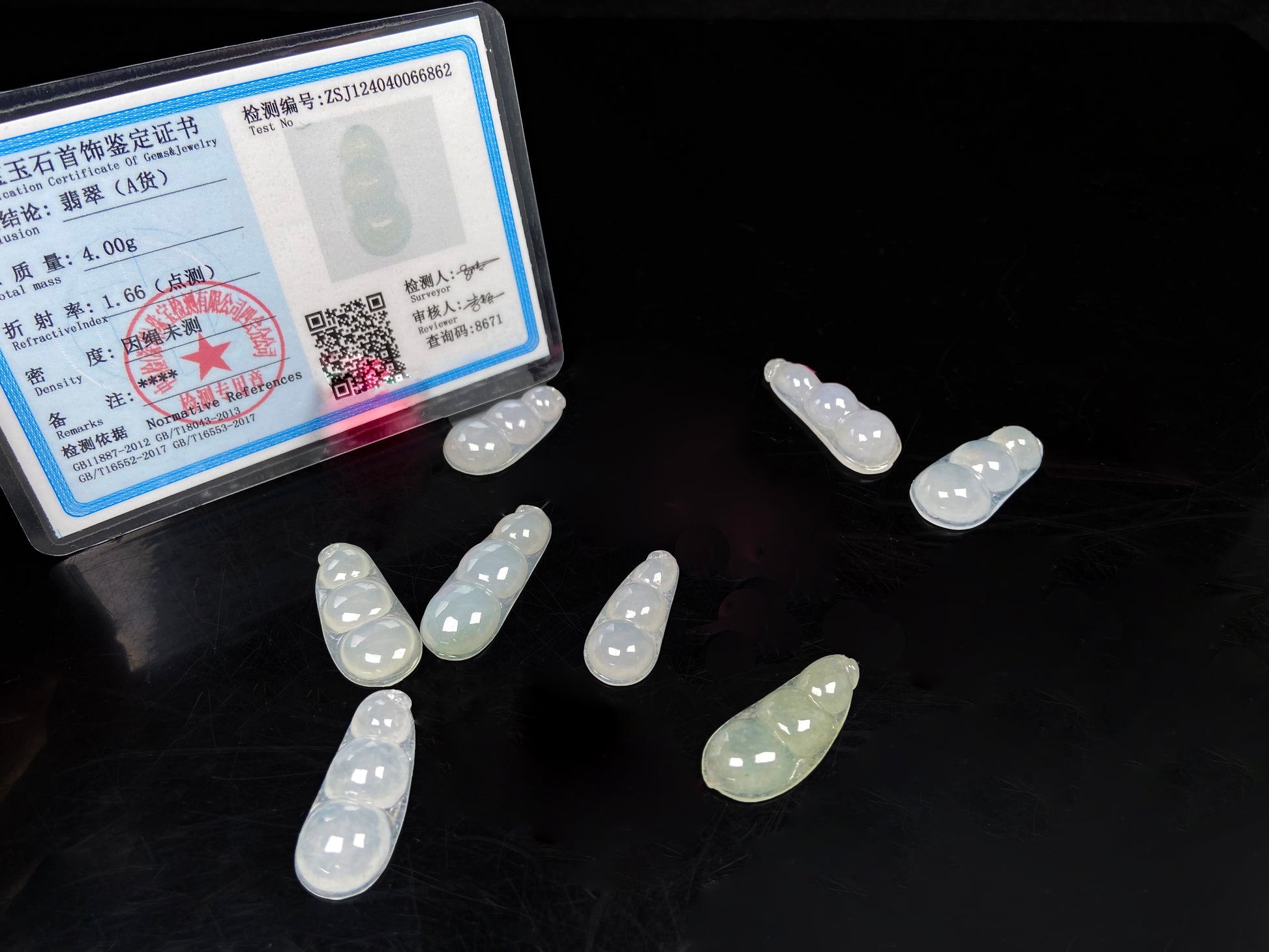 A group of pale green and icy white lucky pea pod loose jadeite.