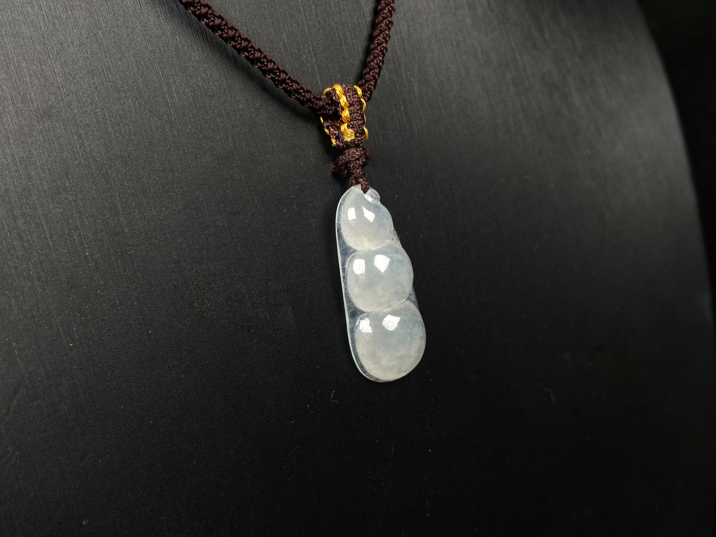 A pale green and icy white lucky pea pod jadeite pendant.