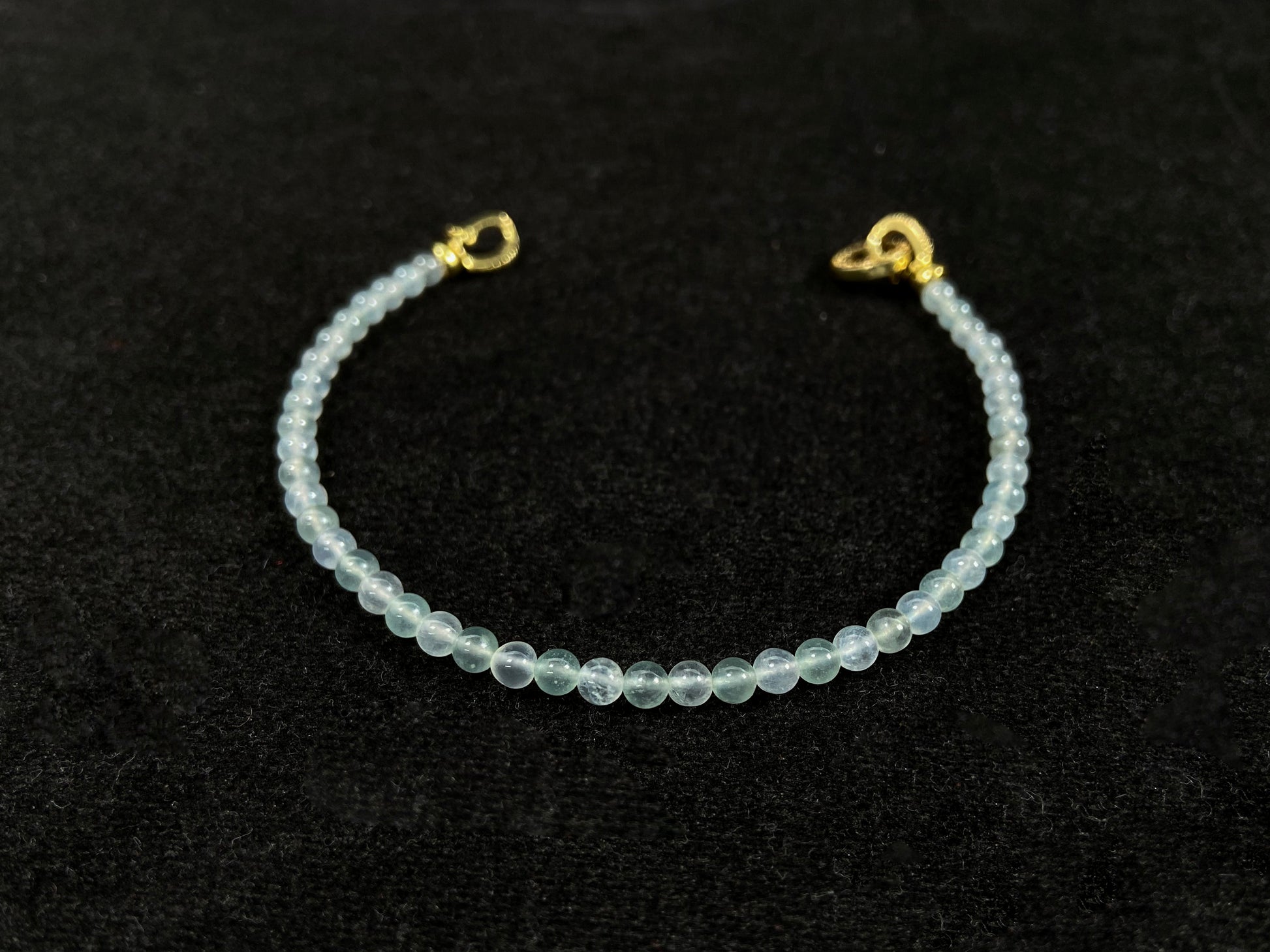An icy jade bead bracelet with a golden clasp.