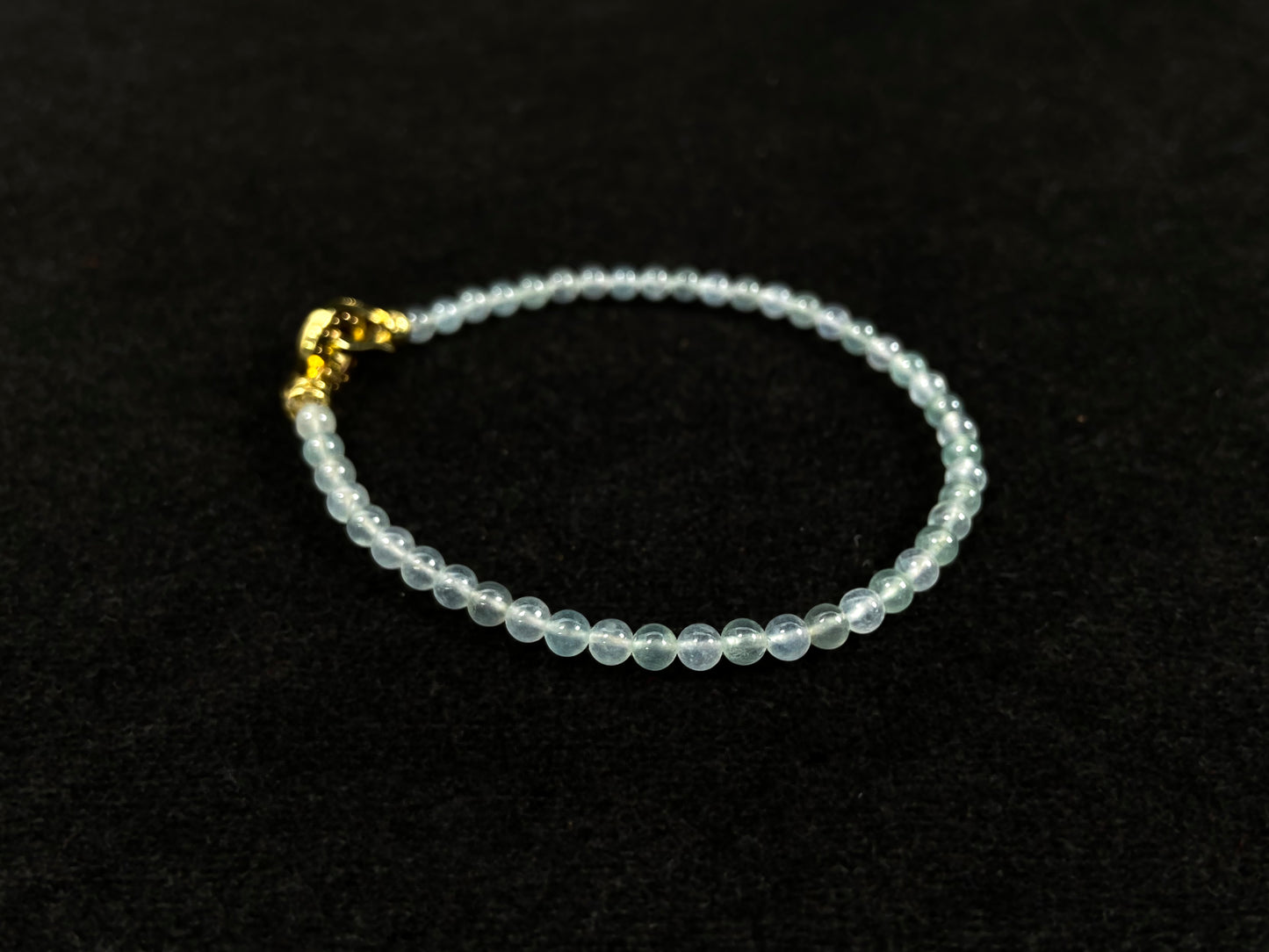 An icy jade bead bracelet with a golden clasp.