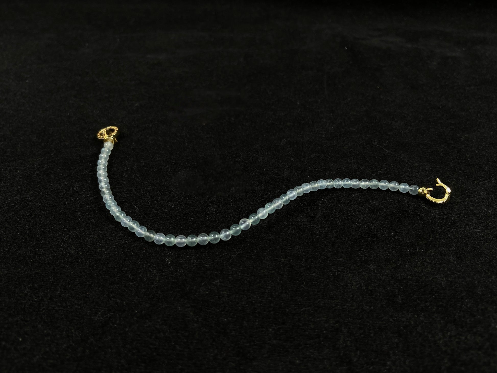 An icy jade bead bracelet with a golden clasp.