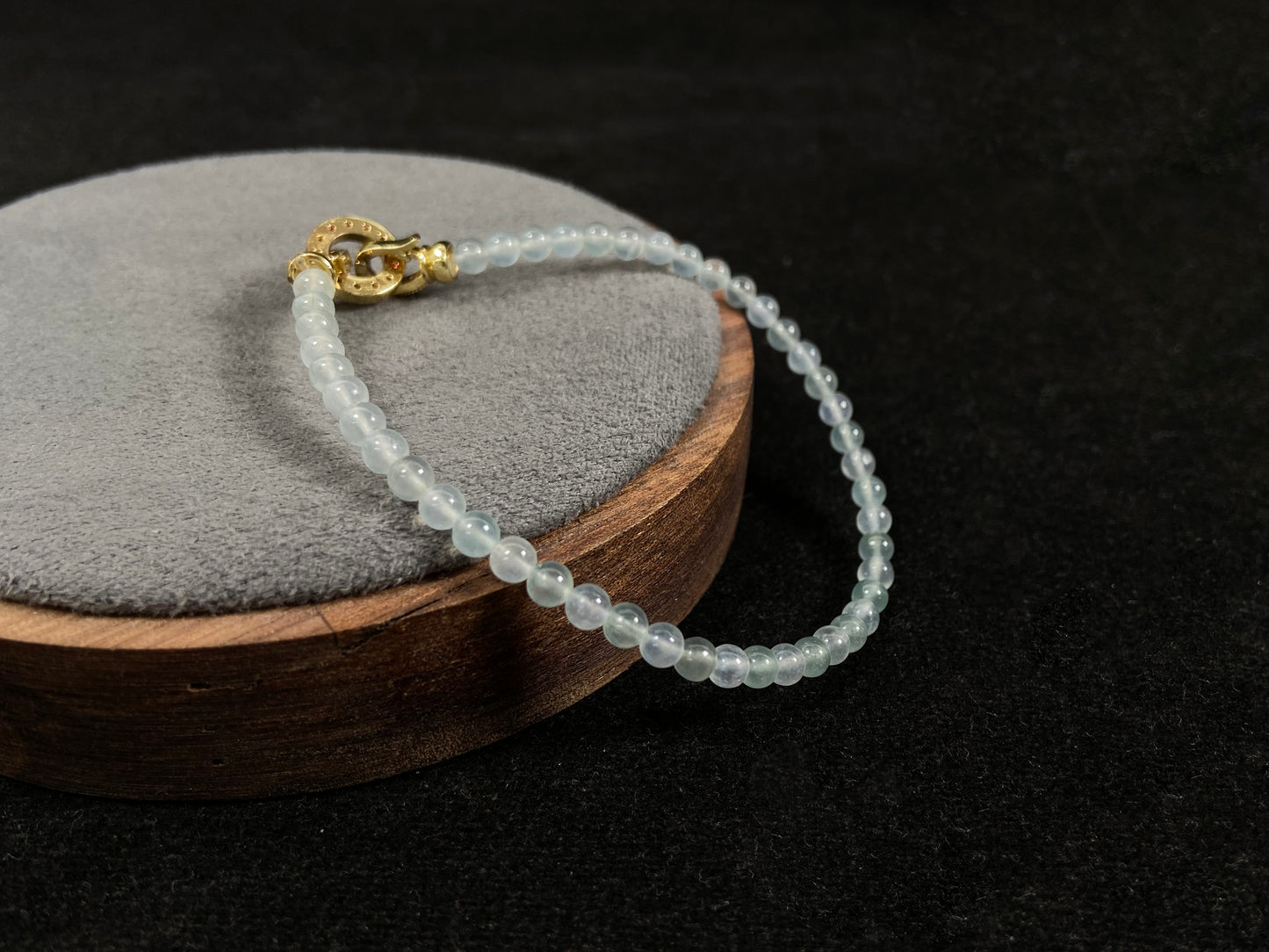 An icy jade bead bracelet with a golden clasp.