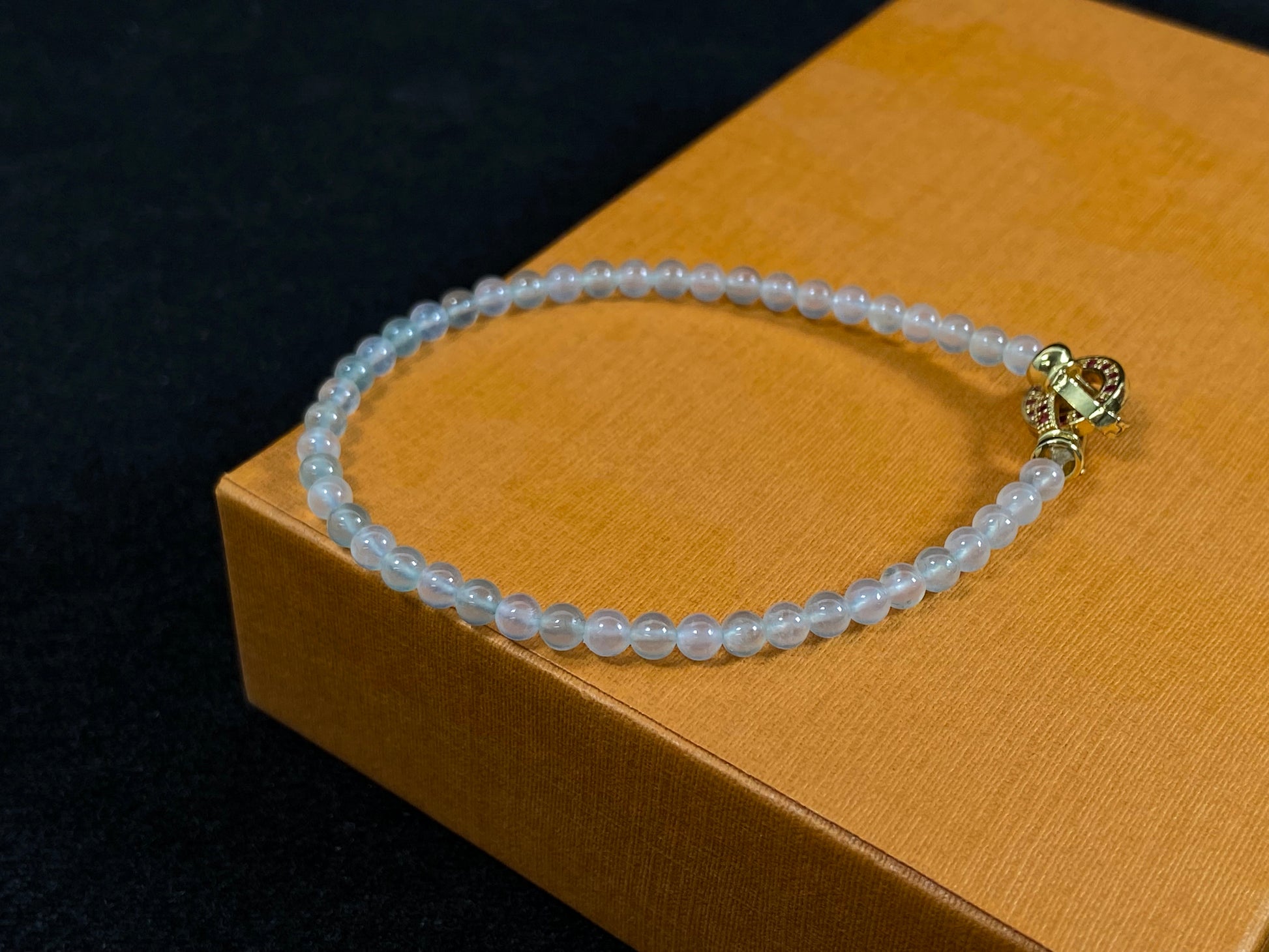 An icy jade bead bracelet with a golden clasp.