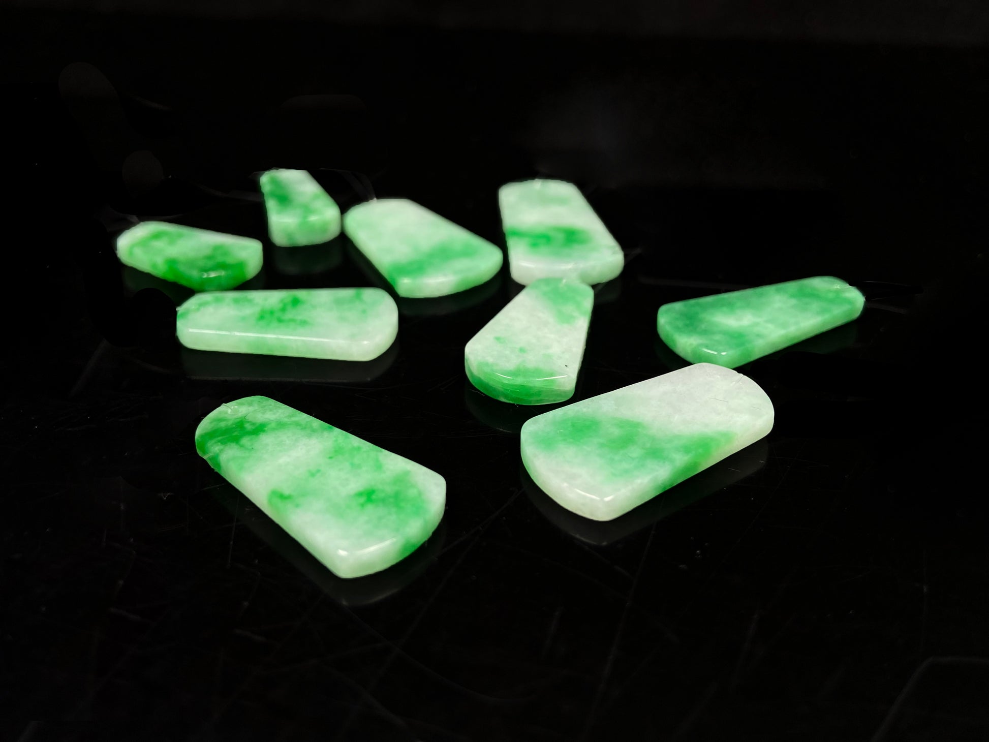 A floating green Wu Shi Pai loose jadeite group.