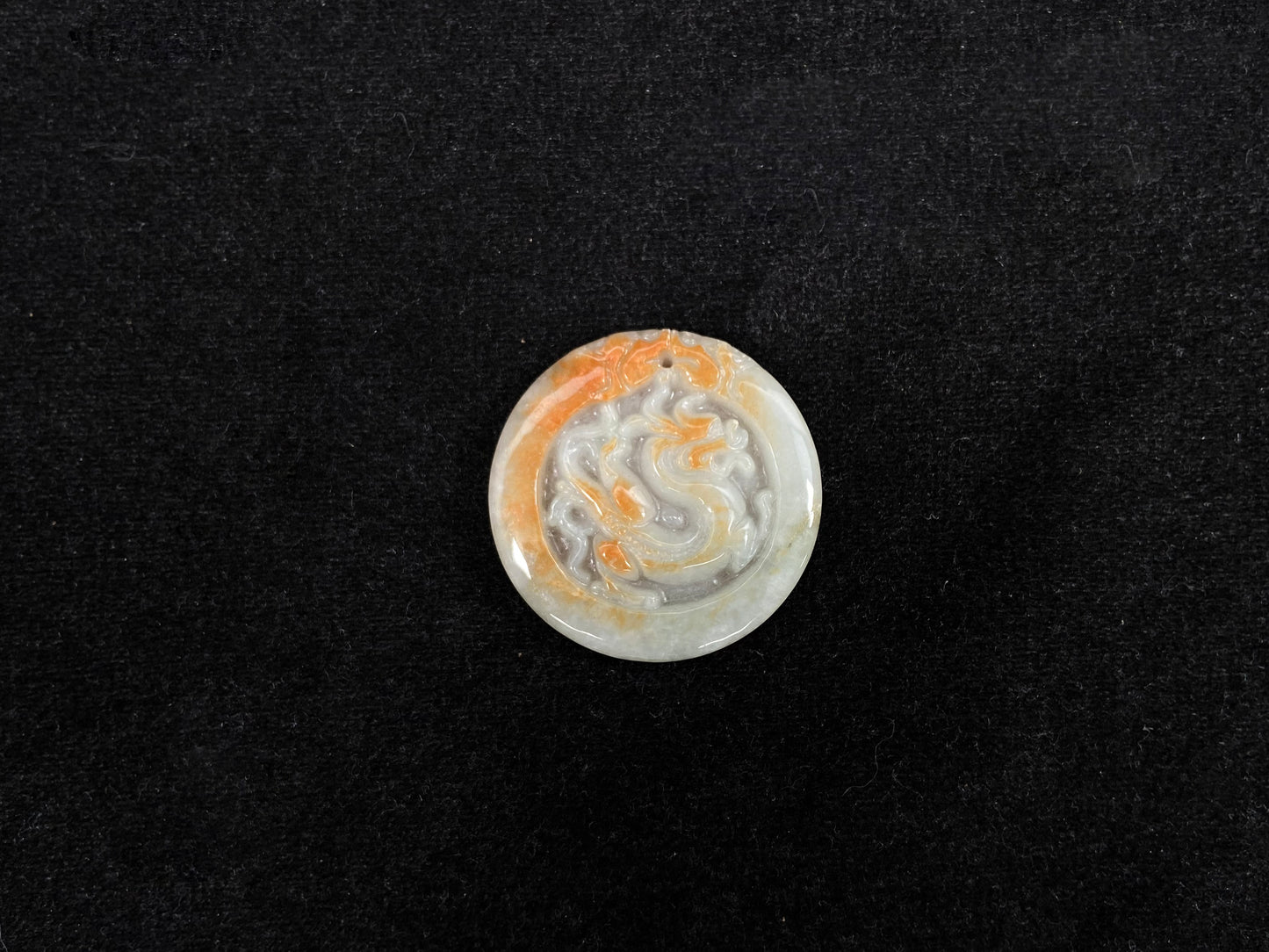 A milky white jadeite dragon plaque with gold speckles.