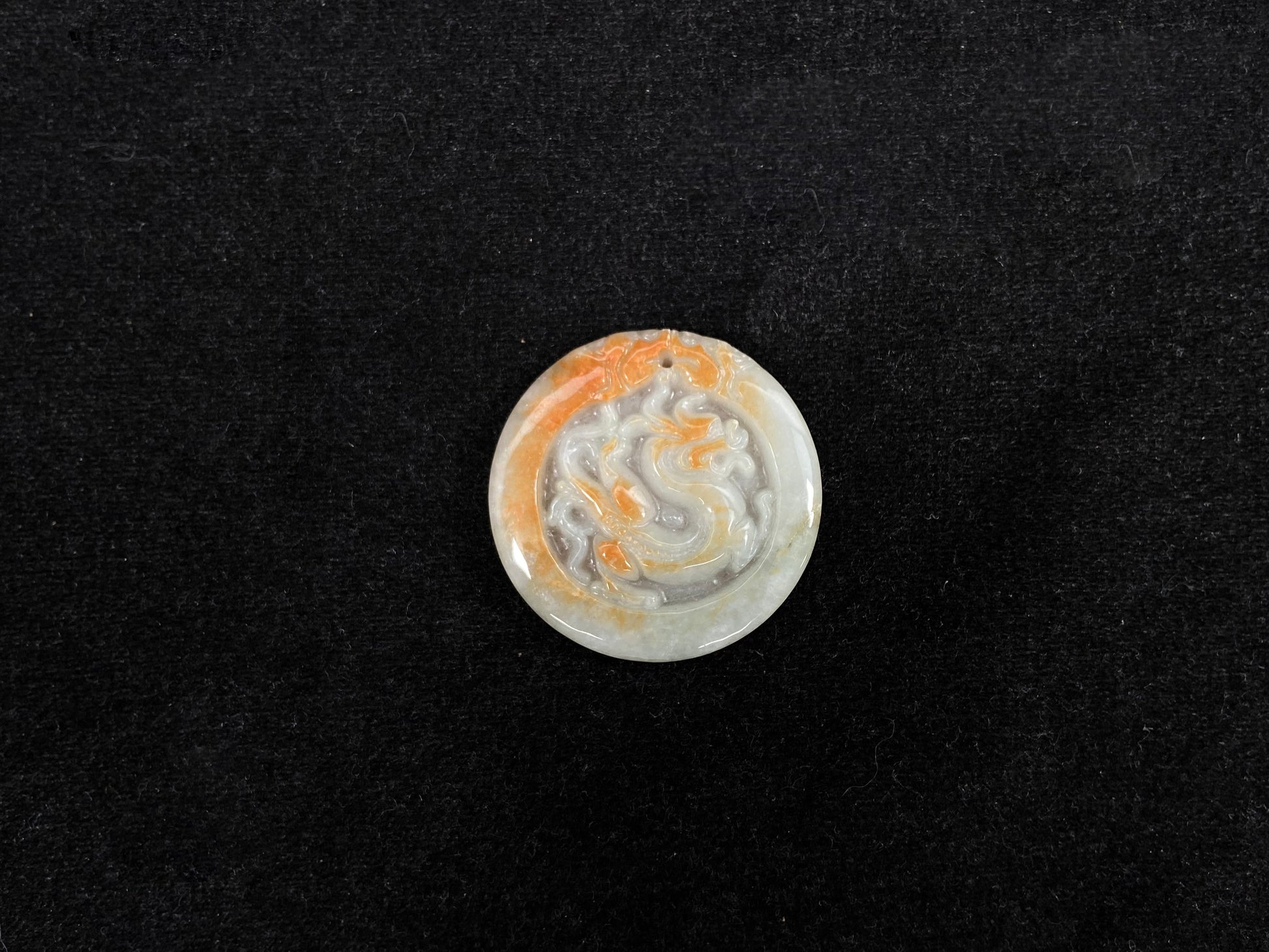 A milky white jadeite dragon plaque with gold speckles.