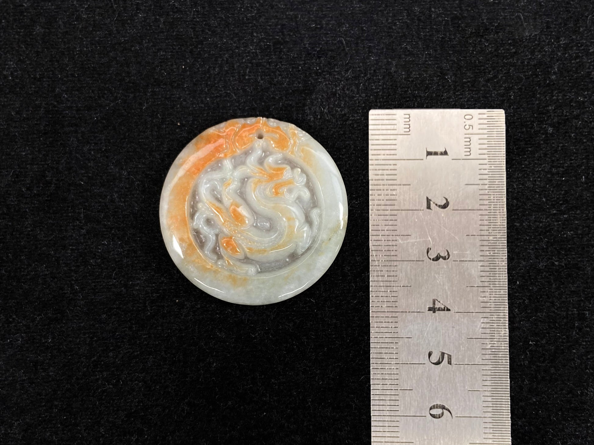 A milky white jadeite dragon plaque with gold speckles.