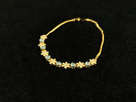 This bracelet features icy jadeite cabochons and diamond-covered gold flowers, alternately set in gold-plated 925 silver.