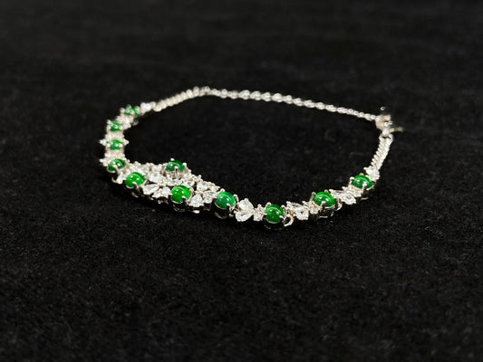 This elegant bracelet features green jade cabochons claw-set in 925 silver, with petal-shaped settings adorned with diamonds.