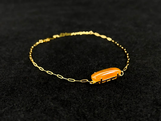 A saddle-shaped jadeite bracelet in a golden brown hue.