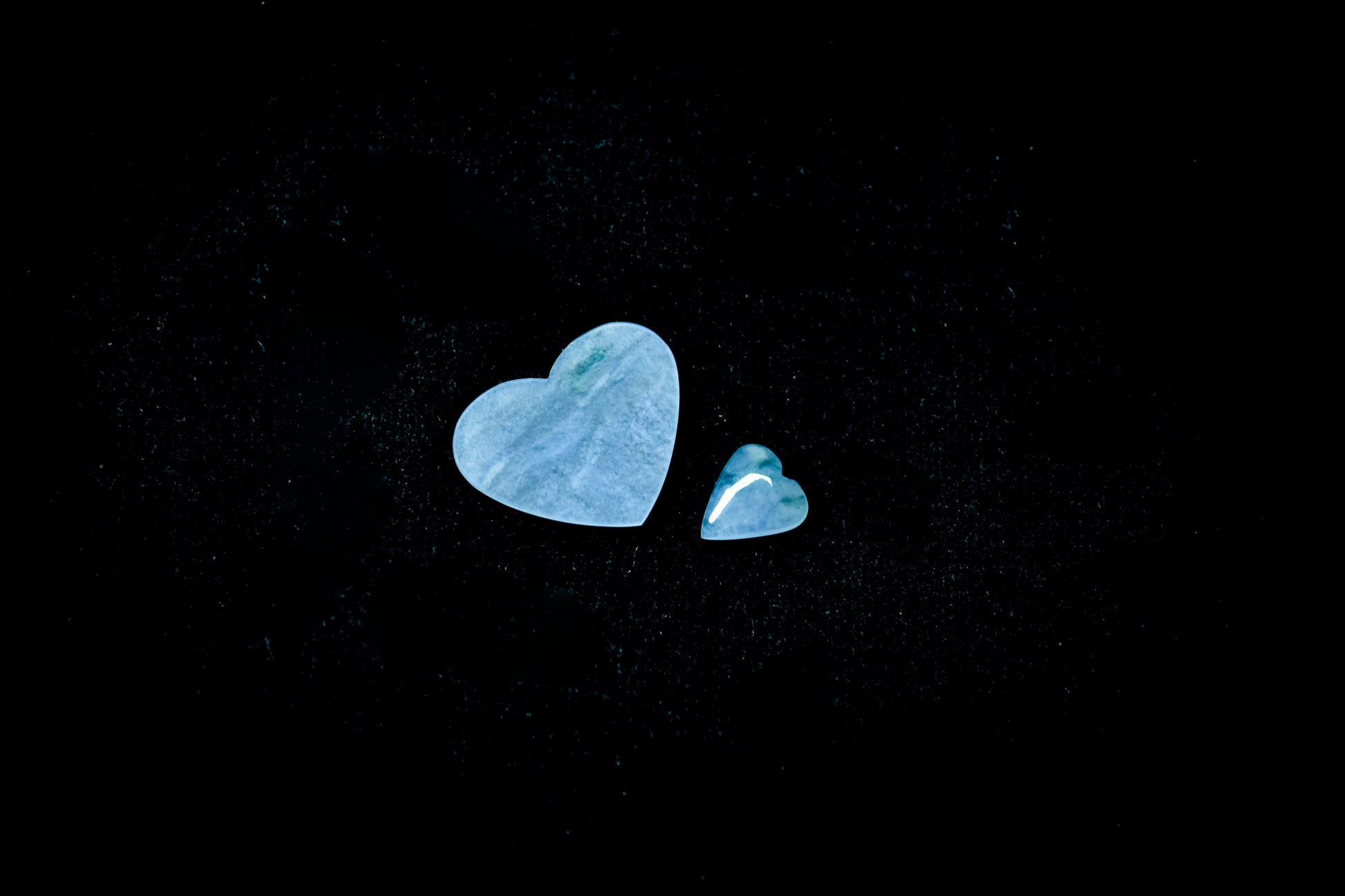 A heart shaped jade stone in a soft blue hue with wispy inclusions.