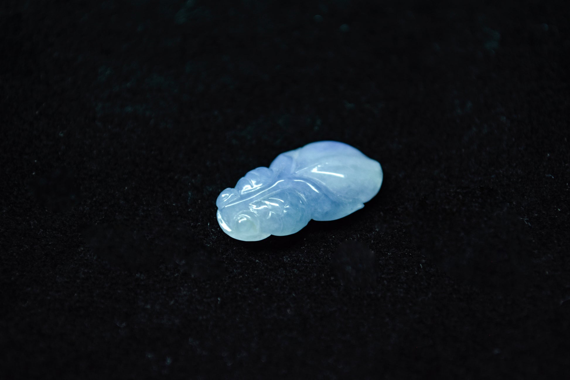 Blue jade pendant on a black background