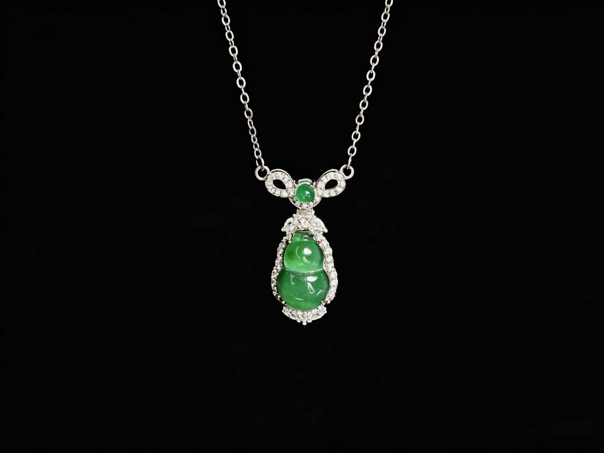 A glossy green lucky gourd jadeite pendant.