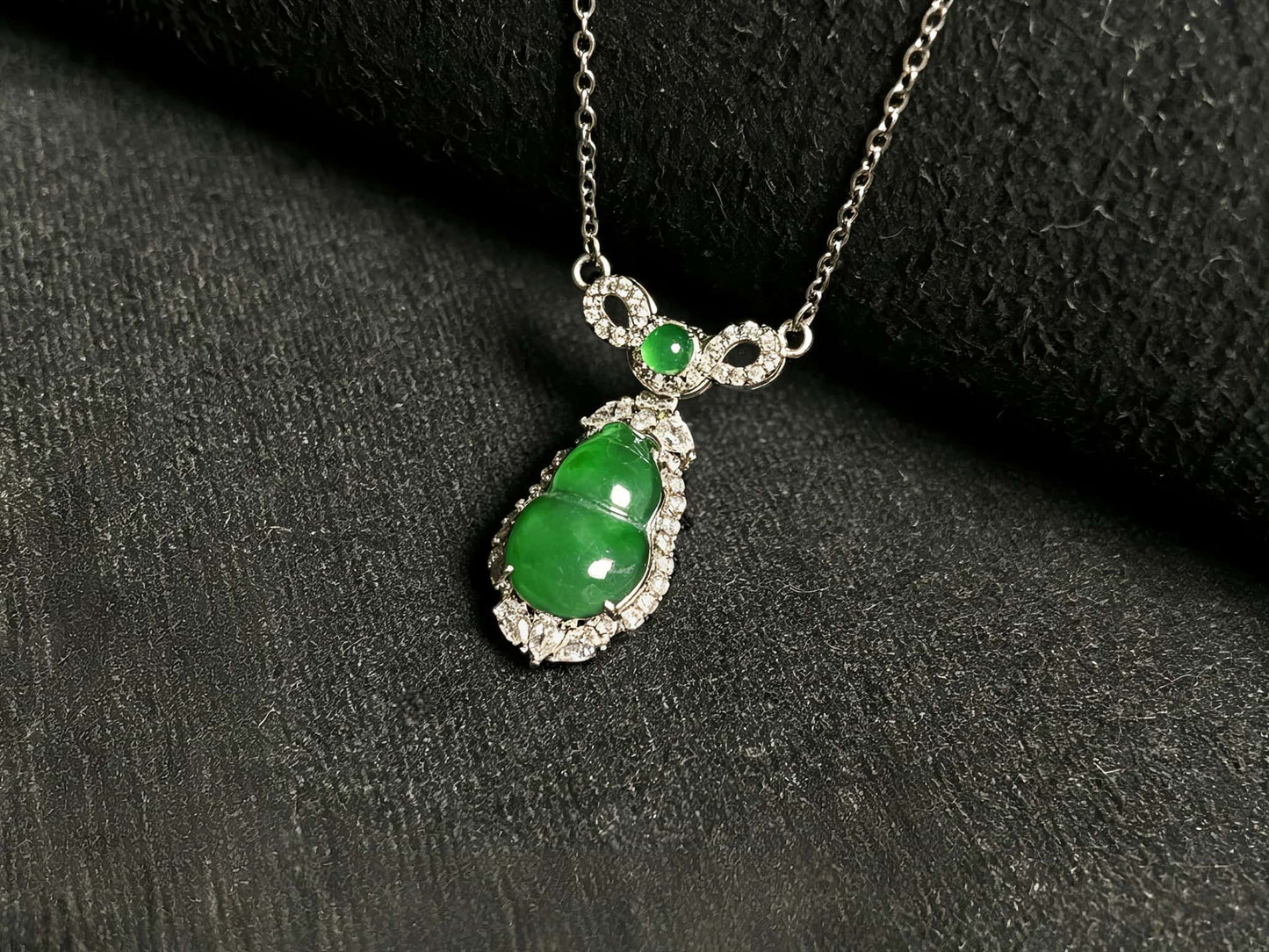 A glossy green lucky gourd jadeite pendant.
