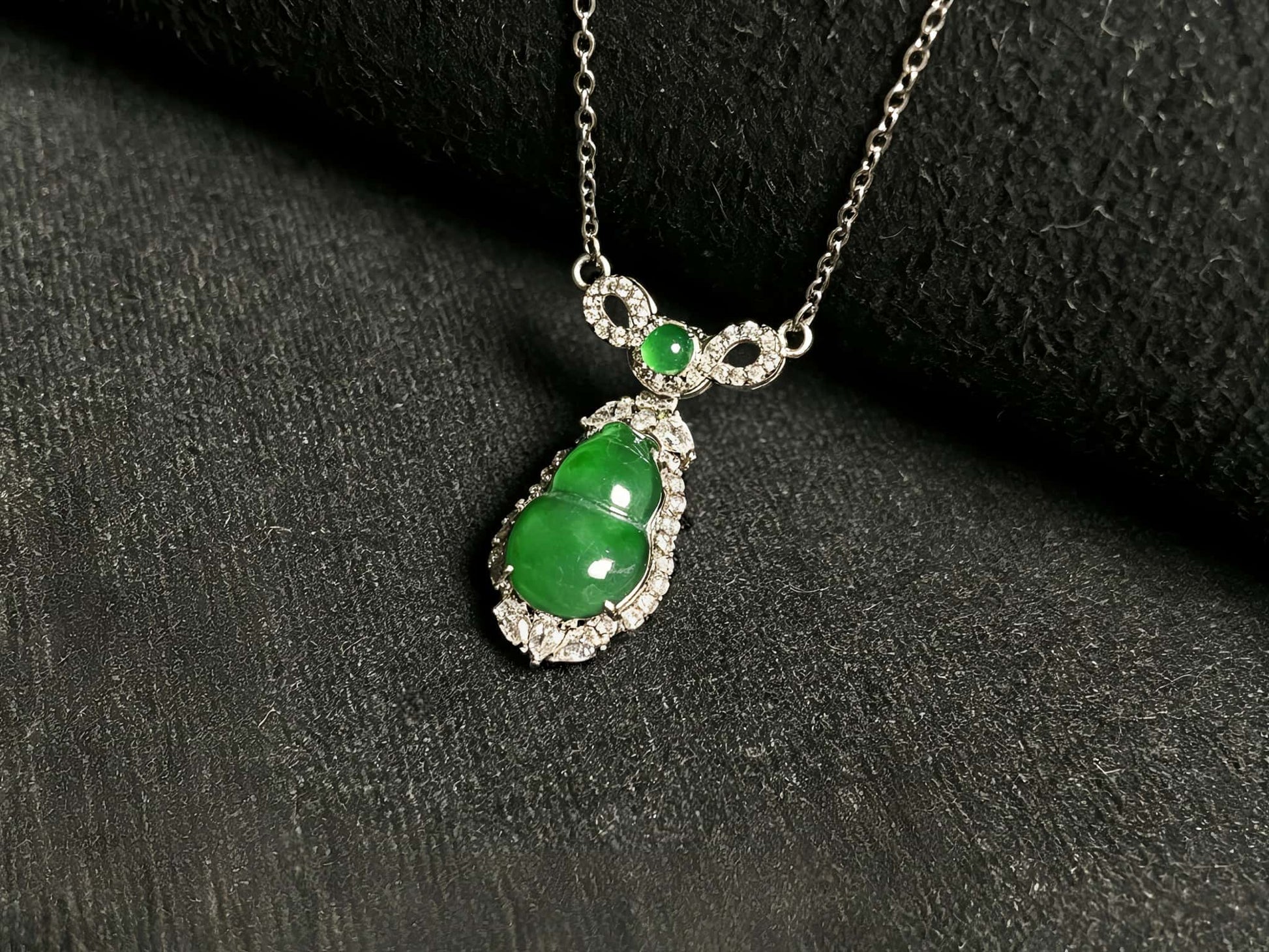 A glossy green lucky gourd jadeite pendant.