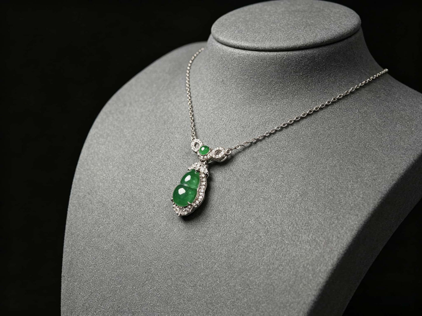 A glossy green lucky gourd jadeite pendant.