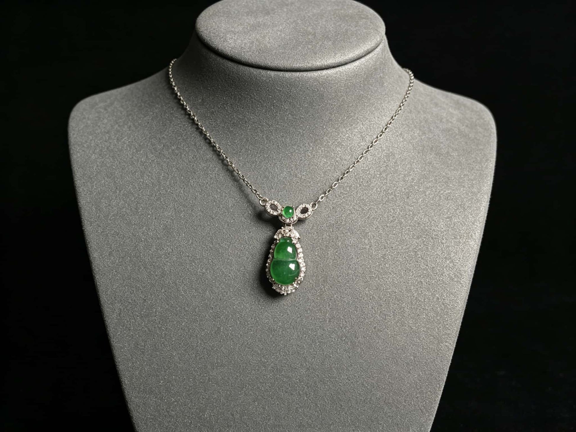 A glossy green lucky gourd jadeite pendant.
