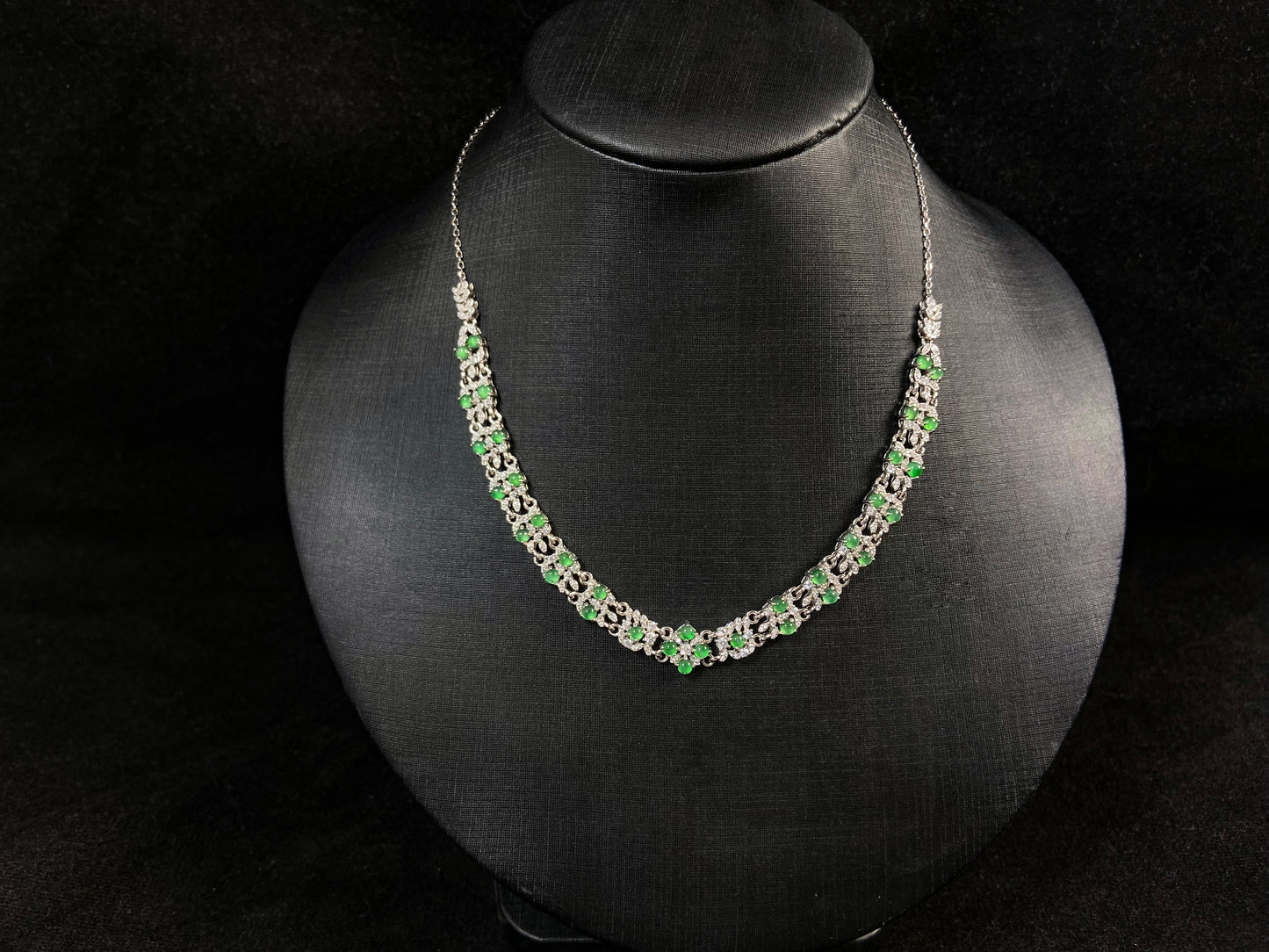 A necklace set with vibrant green jadeite cabochons.