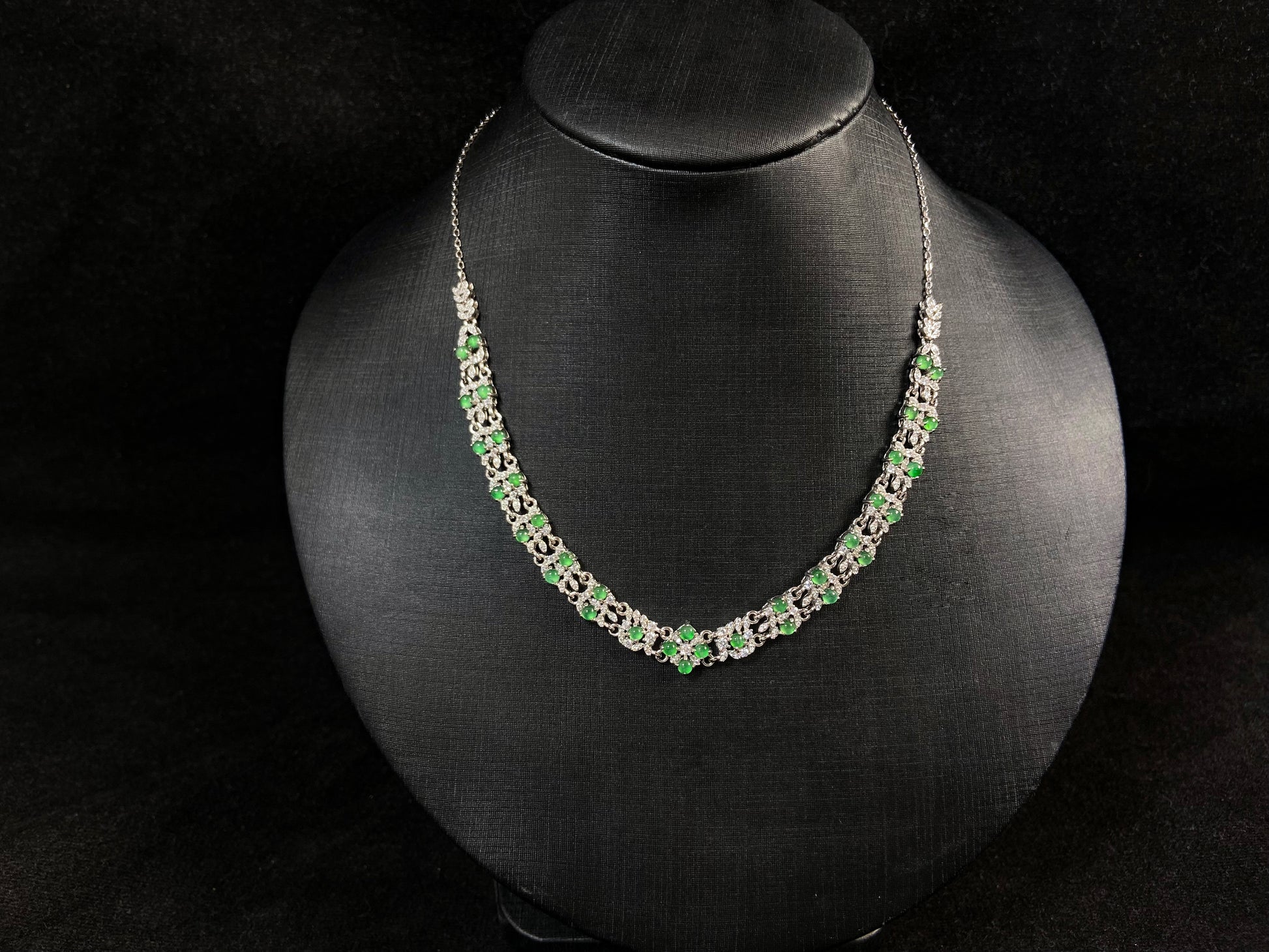 A necklace set with vibrant green jadeite cabochons.