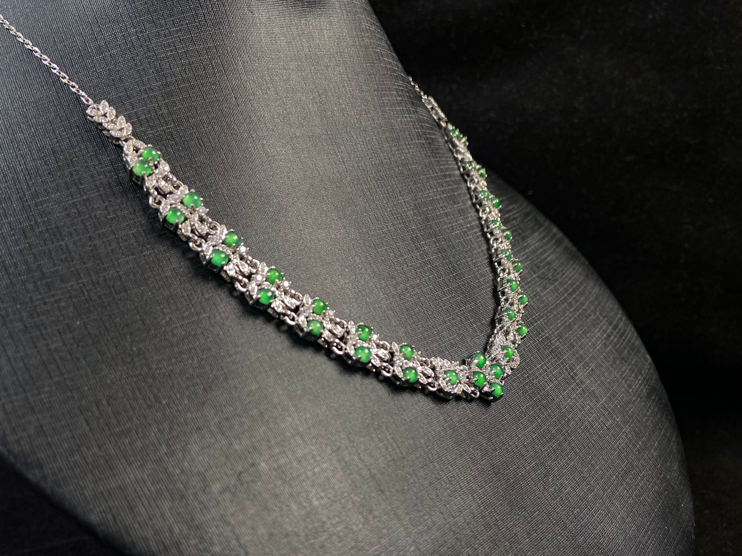 A necklace set with vibrant green jadeite cabochons.