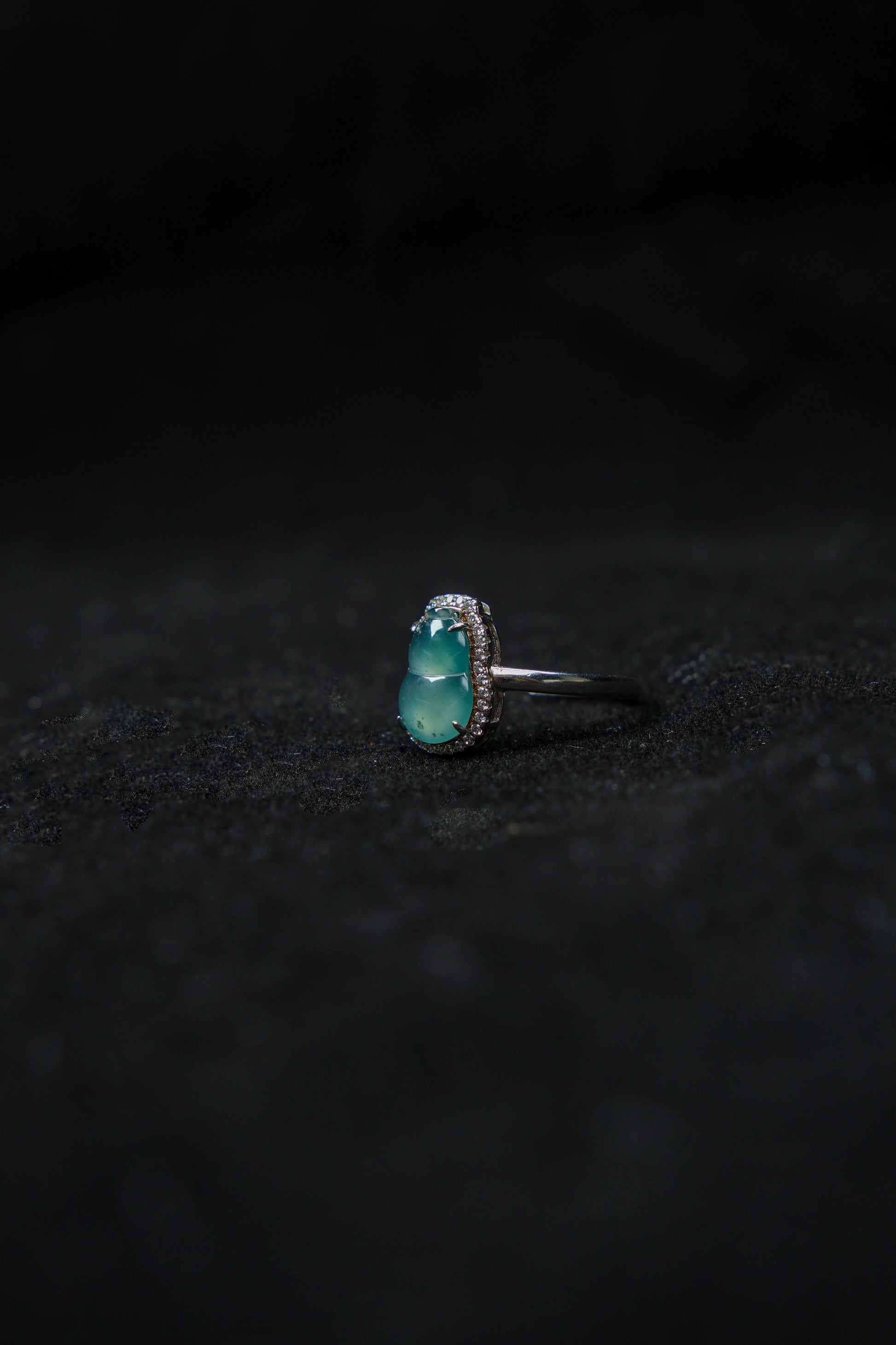 Silver ring with a turquoise stone on a black textured background
