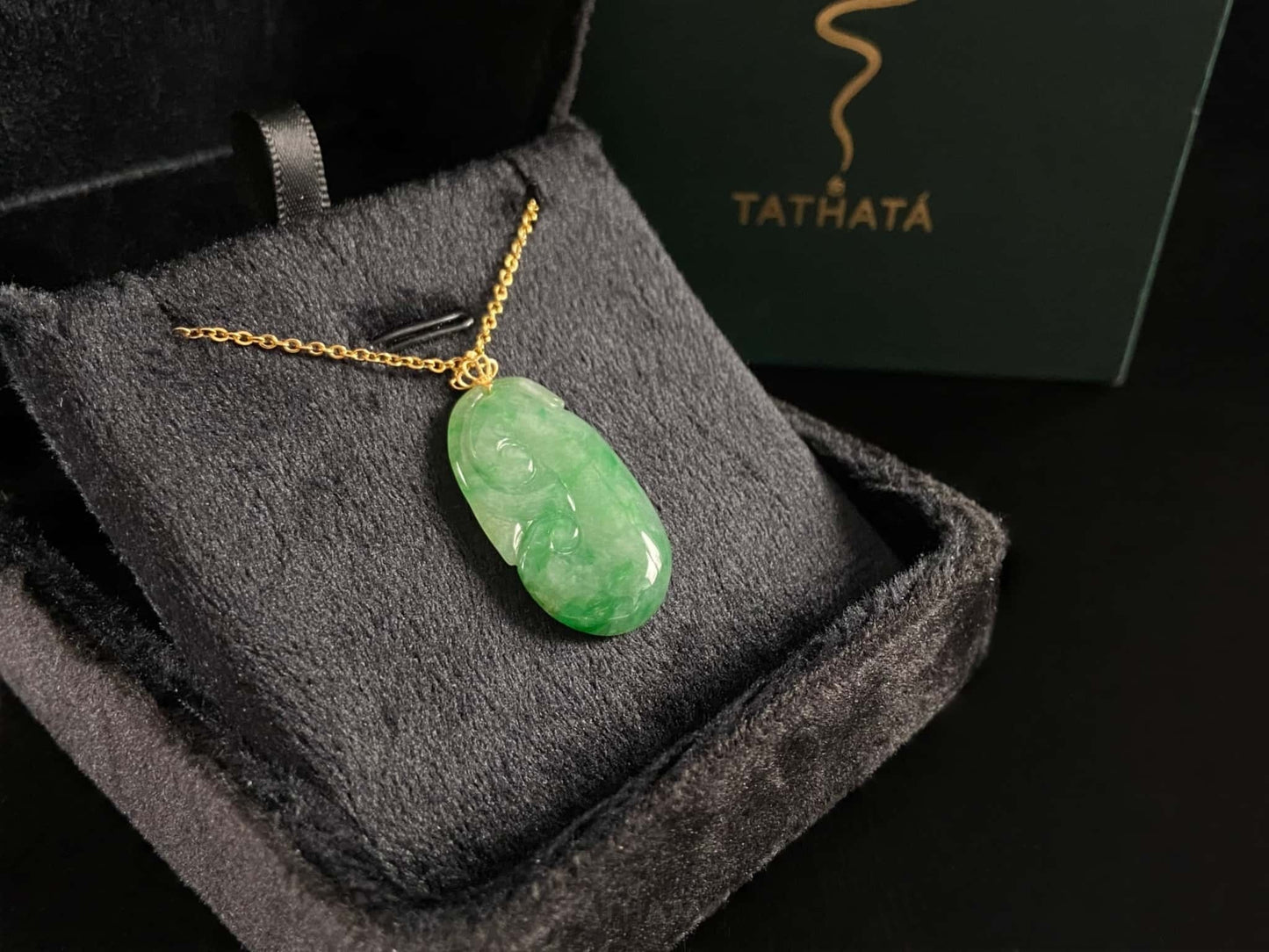 A foat green Ruyi jadeite pendant.