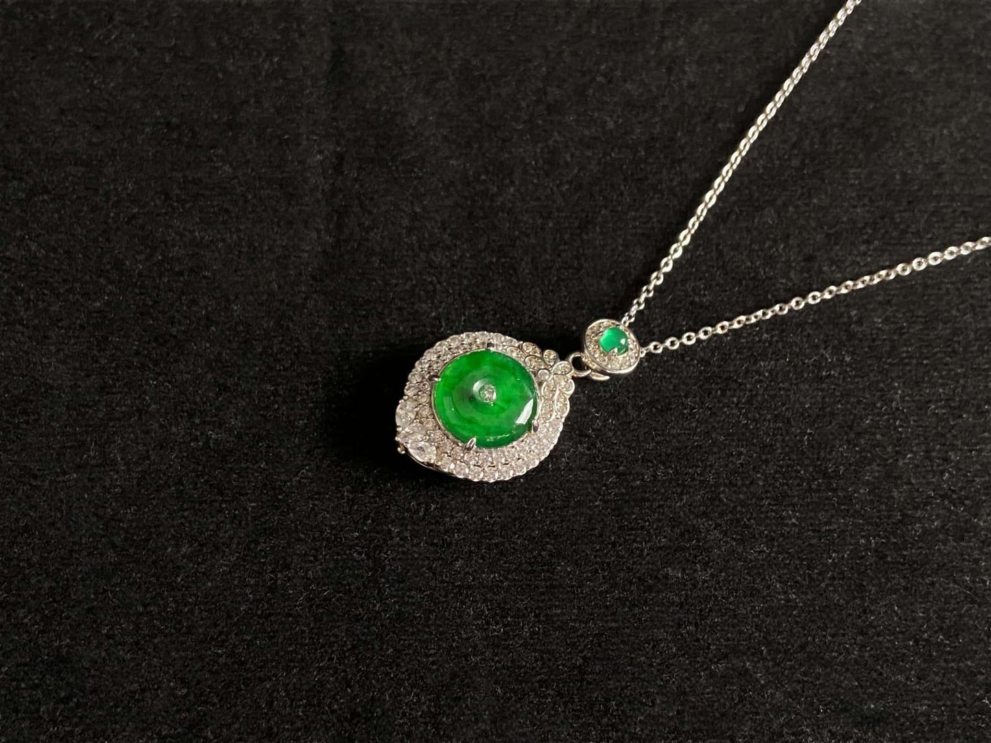 A verdant halo peace disc jadeite pendant.